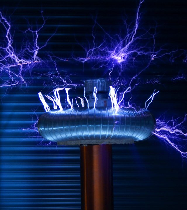 A Tesla coil producing powerful electric arcs in a dark setting.
